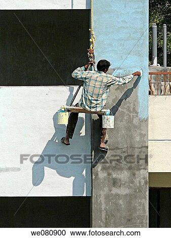 A Painter is seating on a cradle and working on a building's exterior painting work Pune, Maharashtra, India View Large Photo Image Stock Image - A Painter is seating on a cradle and working on a building's exterior painting work Pune, Maharashtra, India. Fotosearch