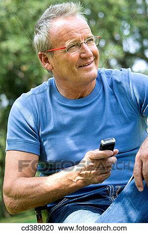 Stock Image - absent-mindedness, cell phone, baby boomer, Absent-minded. Fotosearch