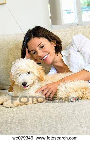 Stock Photograph - at-home, caress, calm, brunette, animal. Fotosearch