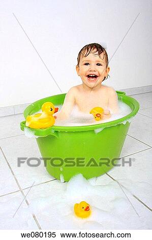 Baby sitting in tub, having a bath with lots of soap foam and yellow plastic ducks View Large Photo Image Stock Photography - Baby sitting in tub, having a bath with lots of soap foam and yellow plastic ducks. Fotosearch