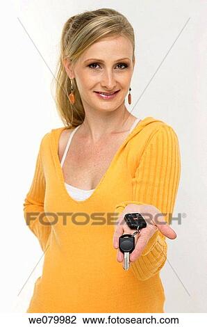 Blond woman posing in the studio showing car keys View Large Photo Image Stock Image - Blond woman posing in the studio showing car keys. Fotosearch