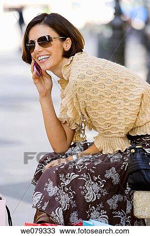 Stock Image - brunette, calling, cell phone. Fotosearch
