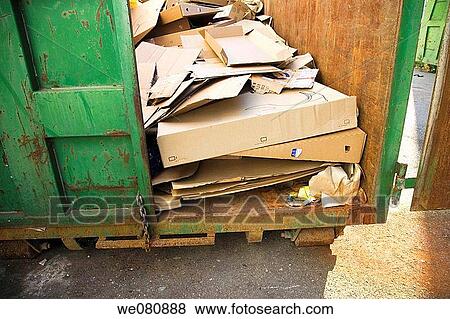 Cardboard in green recycling container View Large Photo Image Stock Photo - Cardboard in green recycling container. Fotosearch