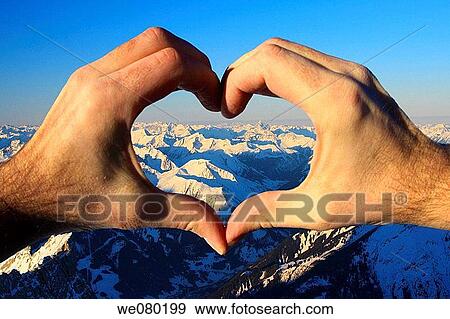 German and Austrian Alps, view from the Zugspitze at sunrise, highest peak in Germany, hands shaping a heart formed window, winter, Bayern, Germany View Large Photo Image Stock Photo - German and Austrian Alps, view from the Zugspitze at sunrise, highest peak in Germany, hands shaping a heart formed window, winter, Bayern, Germany. Fotosearch