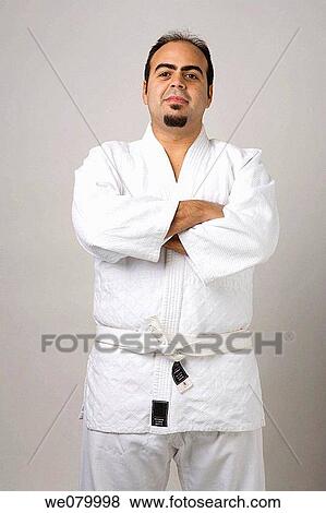 Latin man on karate outfit looking at the camera in a studio setting View Large Photo Image Stock Photo - Latin man on karate outfit looking at the camera in a studio setting. Fotosearch
