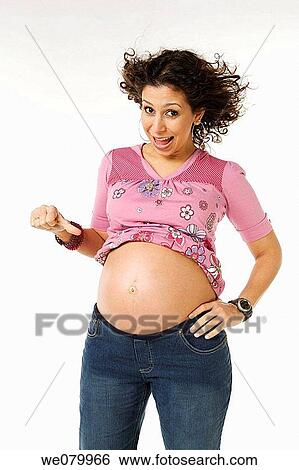 Latin pregnant woman posing in the studio looking at her belly View Large Photo Image Stock Photograph - Latin pregnant woman posing in the studio looking at her belly. Fotosearch