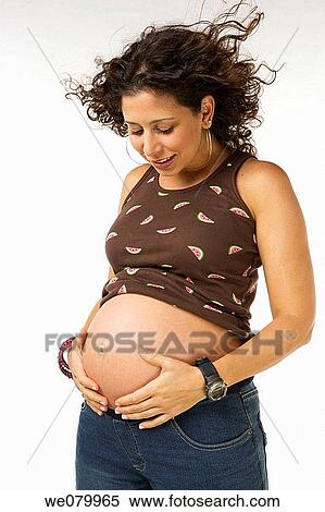 Latin pregnant woman posing in the studio looking at her belly View Large Photo Image Stock Photography - Latin pregnant woman posing in the studio looking at her belly. Fotosearch