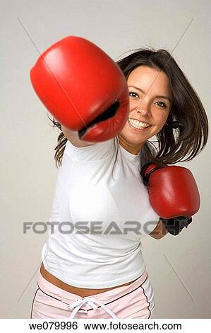 Latin woman wearing boxing gloves throwing punch at the camera View Large Photo Image Stock Photograph - Latin woman wearing boxing gloves throwing punch at the camera. Fotosearch