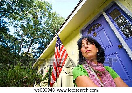 Middle-age woman sitting in front of an American flag on her home. View Large Photo Image Stock Image - Middle-age woman sitting in front of an American flag on her home.. Fotosearch