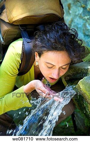 Portrait of a young woman with a backpack drinking in a fountain View Large Photo Image Stock Image - Portrait of a young woman with a backpack drinking in a fountain. Fotosearch