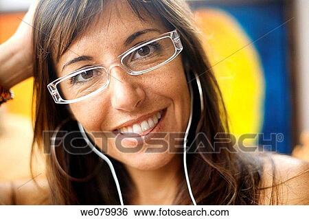 Woman in her late 30s relaxing at home wearing glasses smiling at the camera View Large Photo Image Stock Photograph - Woman in her late 30s relaxing at home wearing glasses smiling at the camera. Fotosearch