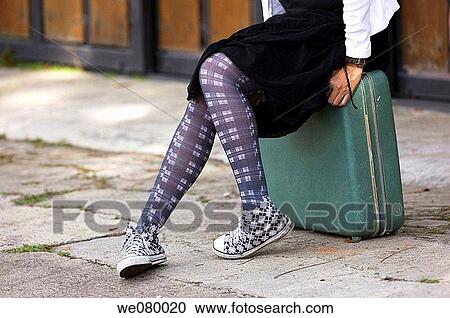 Woman waiting sitting on a suitcase View Large Photo Image Stock Image - Woman waiting sitting on a suitcase. Fotosearch