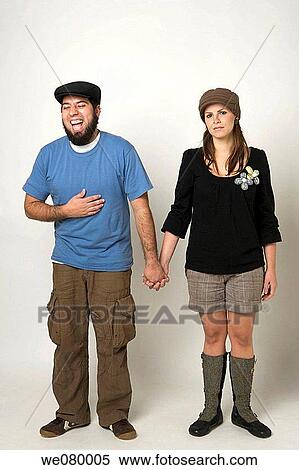 Young man smiling while girlfriend looks mad View Large Photo Image Stock Photography - Young man smiling while girlfriend looks mad. Fotosearch