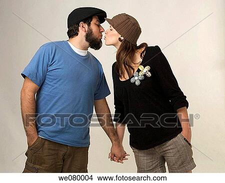 Young trendy couple holding kissing in a studio setting View Large Photo Image Picture - Young trendy couple holding kissing in a studio setting. Fotosearch