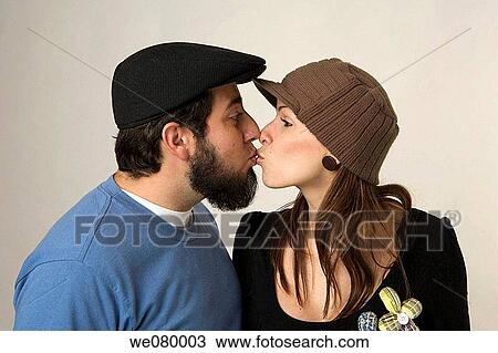 Young trendy couple holding kissing in a studio setting View Large Photo Image Stock Image - Young trendy couple holding kissing in a studio setting. Fotosearch