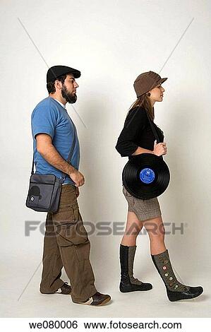 Young trendy couple walking in a studio setting View Large Photo Image Stock Photograph - Young trendy couple walking in a studio setting. Fotosearch