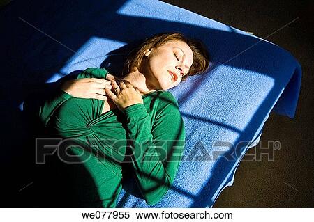 Young woman lying on her bed View Large Photo Image Stock Photography - Young woman lying on her bed. Fotosearch
