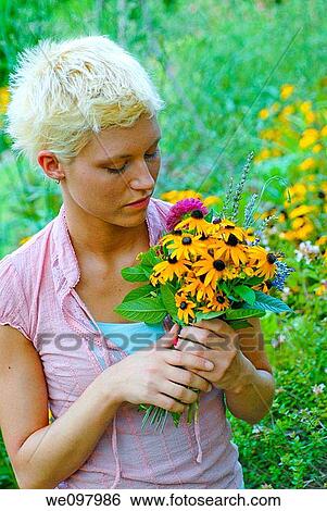 21 year old blond woman in a summer garden holding a bouquet of perennial flowers View Large Photo Image Stock Photograph - 21 year old blond woman in a summer garden holding a bouquet of perennial flowers. Fotosearch