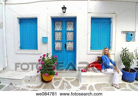 Stock Image - 30 year old woman and 6 year old girl in front of house, Paros, Cyclades islands, Greece. Fotosearch