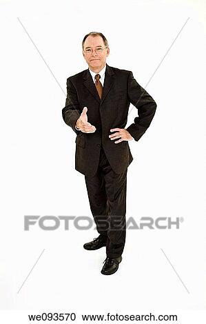 Stock Image - A caucasian businessman with a receding hairline wearing a black business suit and white shirt He is shown on a white background reaching out to shake someone's hand and is smiling. Fotosearch