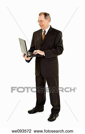 A caucasian businessman with a receding hairline wearing a gray business suit and white shirt He is shown on a white background holding a laptop computer and is smiling View Large Photo Image Stock Image - A caucasian businessman with a receding hairline wearing a gray business suit and white shirt He is shown on a white background holding a laptop computer and is smiling. Fotosearch