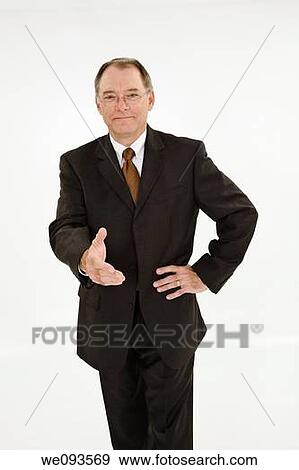 A caucasian businessman with a receding hairline wearing a black business suit and white shirt He is shown on a white background with reaching out shake someone's hand and is smiling View Large Photo Image Stock Photo - A caucasian businessman with a receding hairline wearing a black business suit and white shirt He is shown on a white background with reaching out shake someone's hand and is smiling. Fotosearch