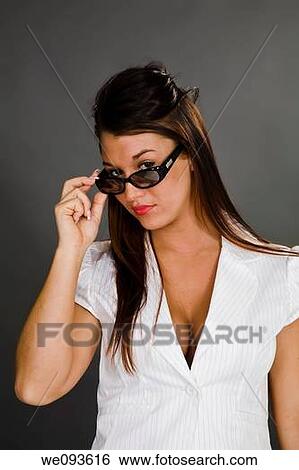 A female caucasian wearing an casual outfit with a white blouse She is on a gray background hold sunglasses View Large Photo Image Stock Photograph - A female caucasian wearing an casual outfit with a white blouse She is on a gray background hold sunglasses. Fotosearch
