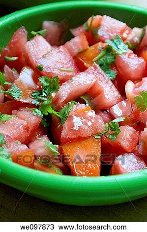 Stock Image - A green bowl of chopped tomatos and cilantro. Fotosearch