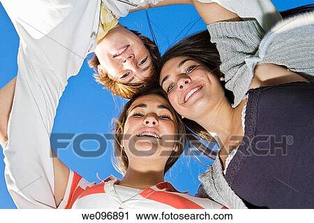 A group of caucasian teens holding onto each other and leaning over looking at the camera while playing in a park View Large Photo Image Stock Image - A group of caucasian teens holding onto each other and leaning over looking at the camera while playing in a park. Fotosearch