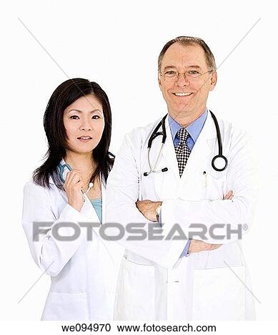 A group of confident doctors smiling over a white background View Large Photo Image Stock Image - A group of confident doctors smiling over a white background. Fotosearch