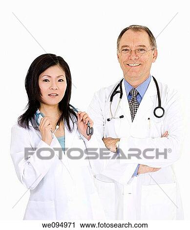 A group of confident doctors smiling over a white background View Large Photo Image Stock Image - A group of confident doctors smiling over a white background. Fotosearch