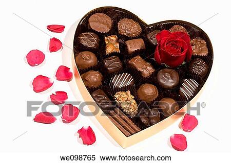A single red rose bud in a heart shaped gold box of milk and dark chocolates, with red rose petals scattered around the box Combines two traditional Valentine's Day gifts View Large Photo Image Stock Photography - A single red rose bud in a heart shaped gold box of milk and dark chocolates, with red rose petals scattered around the box Combines two traditional Valentine's Day gifts. Fotosearch