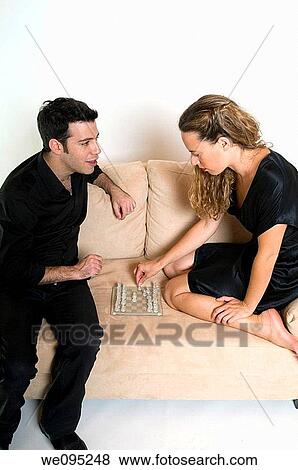 A young couple in their 20s sharing an intimate moment playing chess on a sofa on a white background Model Releases available View Large Photo Image Stock Photo - A young couple in their 20s sharing an intimate moment playing chess on a sofa on a white background Model Releases available. Fotosearch