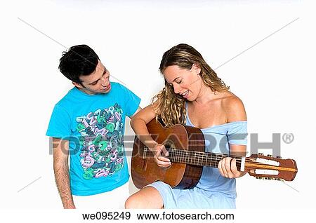 A young couple in their 20s sharing an intimate moment, playing a guitar and singing together on a white background Model Releases available View Large Photo Image Stock Photo - A young couple in their 20s sharing an intimate moment, playing a guitar and singing together on a white background Model Releases available. Fotosearch