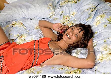 African American woman laying in bed talking on cell phone View Large Photo Image Stock Photography - African American woman laying in bed talking on cell phone. Fotosearch