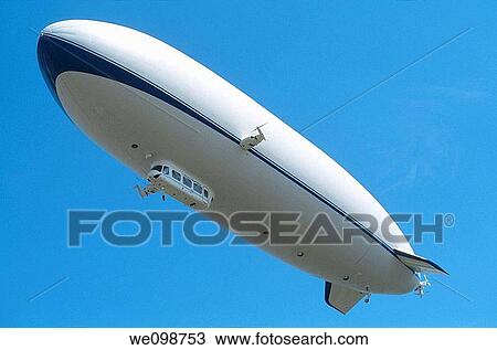 Stock Image - Airship dirigible Zeppelin NT floating in blue sky near Friedrichshafen, Baden-W? rttemberg, Germany. Fotosearch
