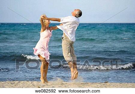 Stock Image - amusement, beach, barefoot, Arms open, action. Fotosearch