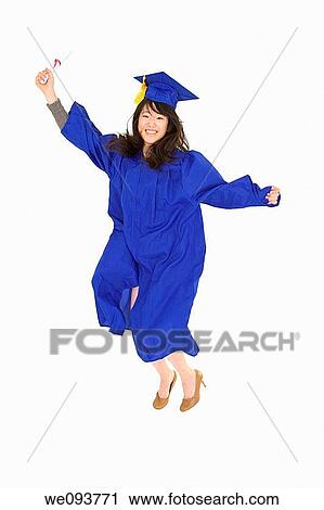 Stock Image - An Asian teenage in blue graduation gown and smiling and jumping in joy She is on a white background. Fotosearch