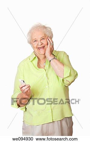 An elderly Caucasian woman listening to music on an mp3 player View Large Photo Image Stock Image - An elderly Caucasian woman listening to music on an mp3 player. Fotosearch