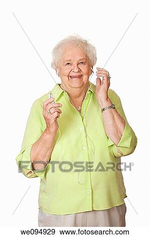 An elderly Caucasian woman listening to music on an mp3 player View Large Photo Image Stock Photo - An elderly Caucasian woman listening to music on an mp3 player. Fotosearch