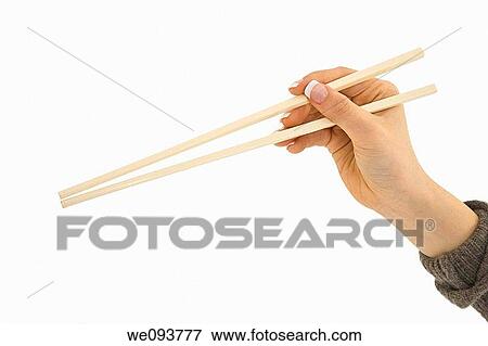 Asian hand holding a pair of chop sticks in front of a white background View Large Photo Image Stock Photo - Asian hand holding a pair of chop sticks in front of a white background. Fotosearch