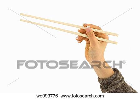 Asian hand holding a pair of chop sticks in front of a white background View Large Photo Image Stock Photograph - Asian hand holding a pair of chop sticks in front of a white background. Fotosearch