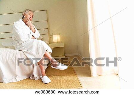 Stock Image - at-home, bed, bathrobe, absorbed. Fotosearch