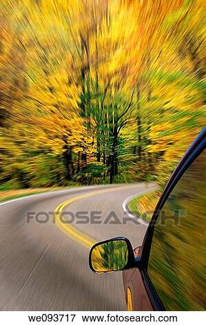 Automobile driving down a country road with the autumn colors and a blured affect View Large Photo Image Stock Photo - Automobile driving down a country road with the autumn colors and a blured affect. Fotosearch
