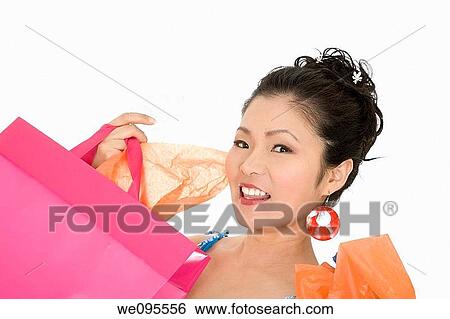 Stock Photograph - Beautiful and sexy Asian woman carrying shopping bags. Fotosearch