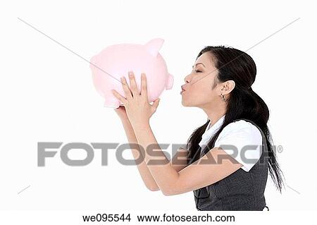 Beautiful Asian businesswoman holding a piggy bank View Large Photo Image Picture - Beautiful Asian businesswoman holding a piggy bank. Fotosearch