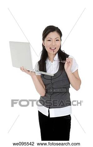 Beautiful Asian businesswoman holding a laptop computer View Large Photo Image Stock Image - Beautiful Asian businesswoman holding a laptop computer. Fotosearch