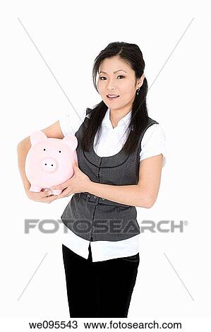 Beautiful Asian businesswoman holding a piggy bank View Large Photo Image Stock Image - Beautiful Asian businesswoman holding a piggy bank. Fotosearch