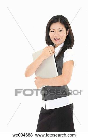 Beautiful Asian businesswoman holding a laptop computer View Large Photo Image Stock Photo - Beautiful Asian businesswoman holding a laptop computer. Fotosearch