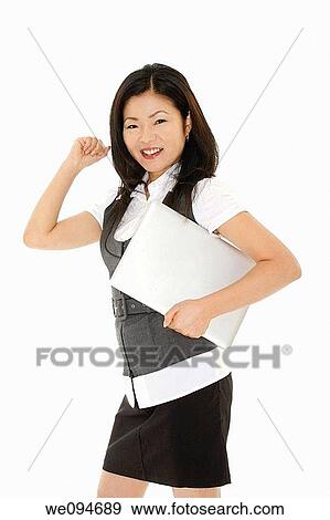Beautiful Asian businesswoman holding a laptop computer View Large Photo Image Stock Photo - Beautiful Asian businesswoman holding a laptop computer. Fotosearch
